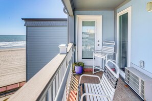 A balcony with a view of the beach, a door, a chair, and a potted plant. - ~ 9 Mi to Boardwalk: Oceanfront Myrtle Beach Condo (Myrtle Beach)