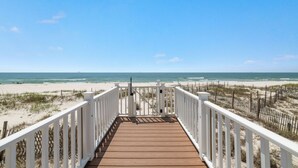 A wooden deck leading to a beach with white railings and a clear view of the ocean. - Amazing 5 Bedroom Gulf Front home with private pool just steps from the Gulf (Gulf Shores)