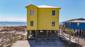 A yellow building with a small porch and a blue structure nearby. - Amazing 5 Bedroom Gulf Front home with private pool just steps from the Gulf (Gulf Shores)