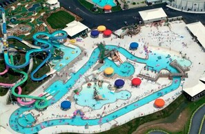 Oversigtsbillede af en vandpark med flere swimmingpools, vandrutsjebaner og liggestole.