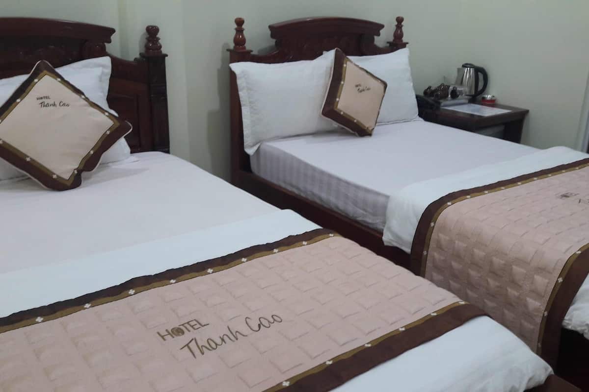 Two hotel beds with white linens and pillows, each with a 'HOTEL Thank Cao' label.