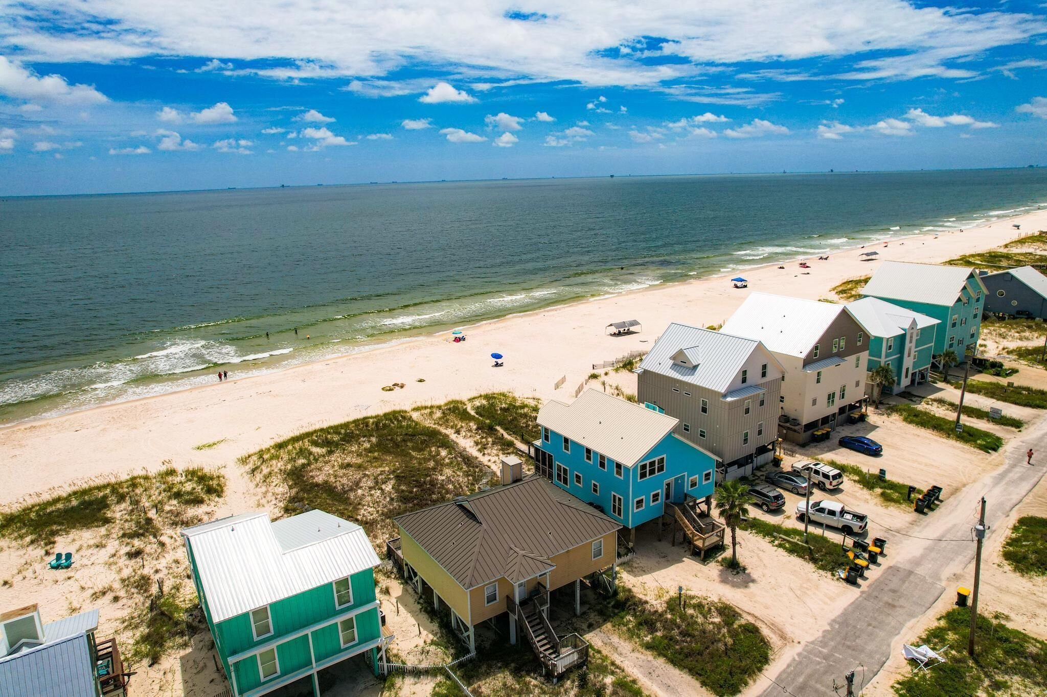 A coastal property with multiple buildings, a beach, and a road.