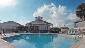 A swimming pool with lounge chairs, a covered pavilion, and a clear sky. - Affordable Renovated 3 Bd/2 Ba home steps from the beach with pool/tennis access (Gulf Shores)
