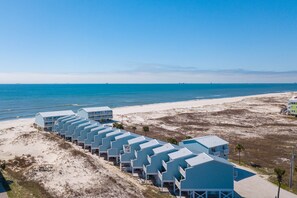 A beachfront hotel with multiple blue-roofed buildings aligned along the shore.