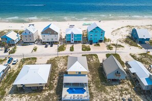 A coastal property with multiple buildings, a swimming pool, and a beach view.