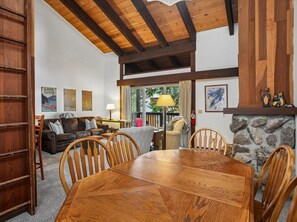 Un salon chaleureux avec une table à manger en bois, une cheminée et un mur en pierre.