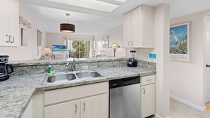 A modern kitchen with granite countertops, stainless steel appliances, and a skylight. - Seaside Escape – Beach Castle #24 by RVA (Longboat Key)