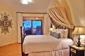 Ein Hotelzimmer mit Bett, Nachttisch, Lampe, Blick ins Freie und einer Wanddekoration.