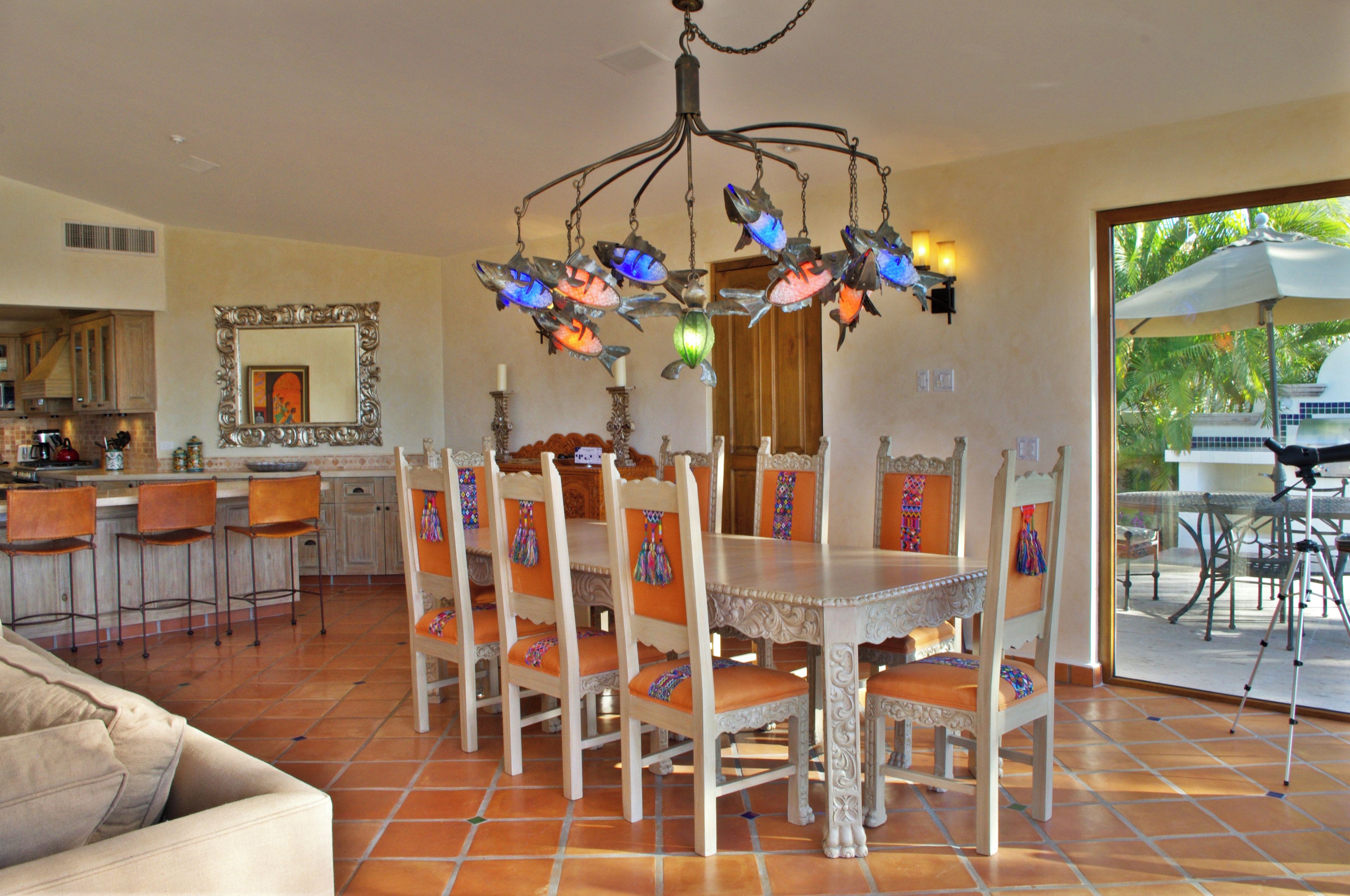 Ein Essbereich mit einer Chandelier, Stühlen und einem Tisch.