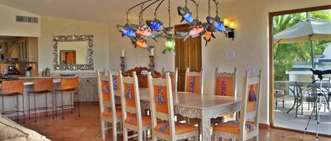 Ein Essbereich mit einer Chandelier, Stühlen und einem Tisch.