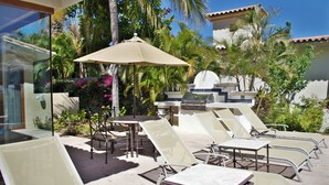 Eine Terrasse im Freien mit Lounge-Möbeln und einem Grill.