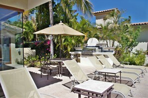 Eine Terrasse im Freien mit Lounge-Möbeln und einem Grill.