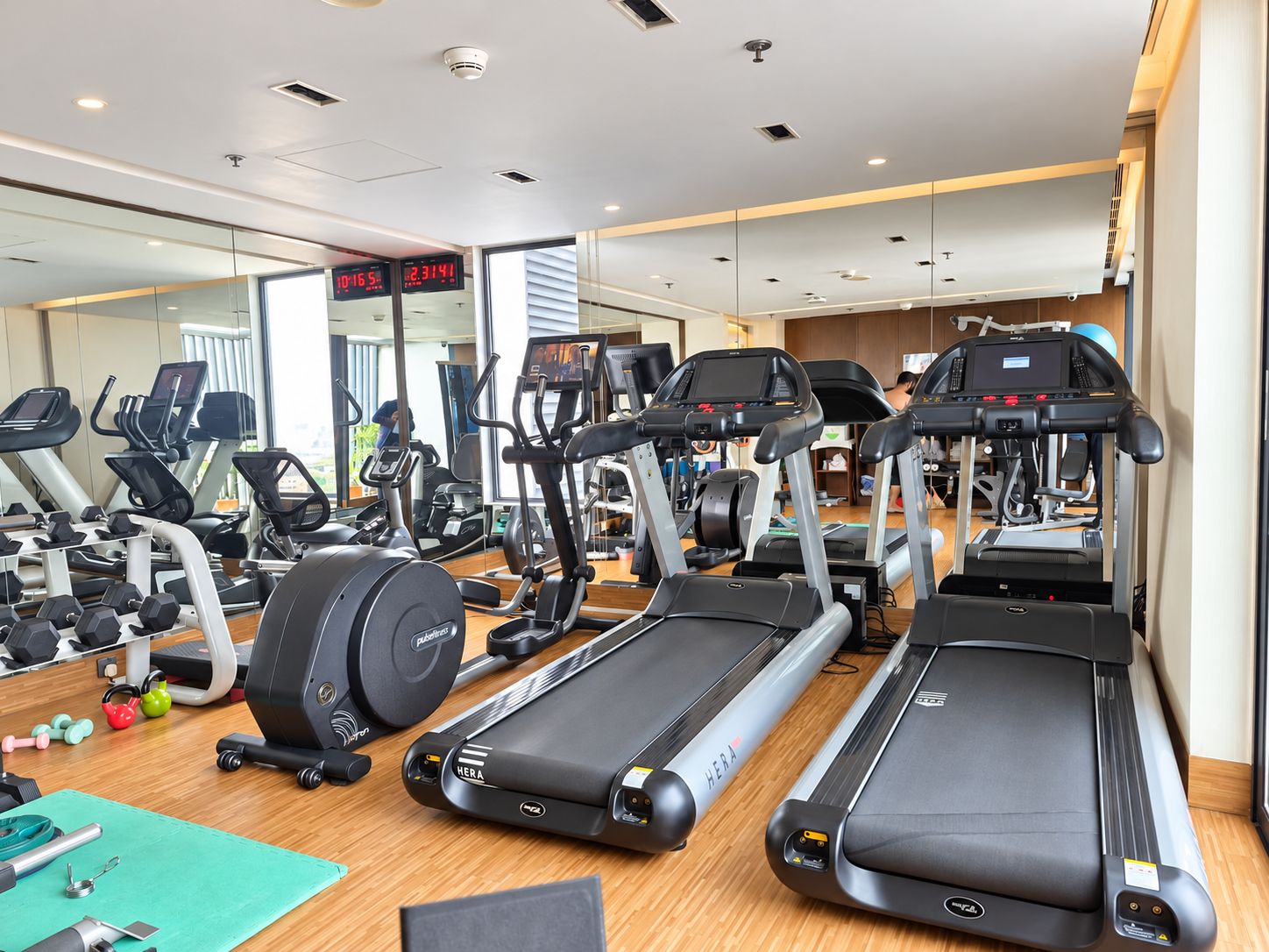 A gym with treadmills, elliptical machines, and free weights.