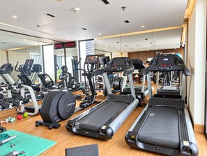 A gym with treadmills, elliptical machines, and free weights. - HANSA - A Premium Residence (Dhaka)