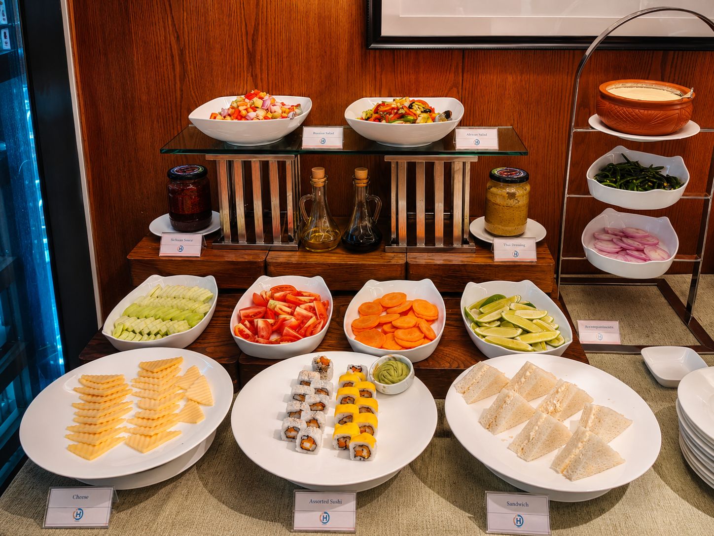 A buffet with various food options including salads, sushi, and sandwiches.