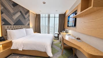 A hotel room with a bed, desk, and TV.