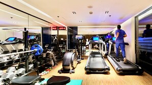 A gym with treadmills, exercise bikes, and weight machines. - HANSA - A Premium Residence (Dhaka)