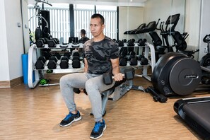A gym with exercise equipment, including dumbbells, treadmills, and a stationary bike. - HANSA - A Premium Residence (Dhaka)