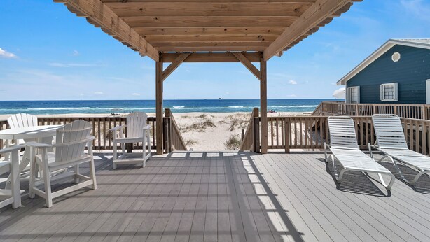 A wooden deck with chairs and sun loungers overlooking a beach. - Gorgeous 4 Bdrm, 3 Ba Gulf Front Private Home, Sleeps 10 (Gulf Shores)
