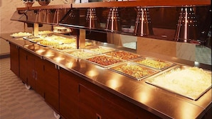 A buffet with various food options, a stainless steel counter, and a wooden cabinet. - Hotel Chalet-Ryuo (Yamanouchi)
