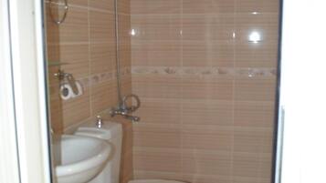 Un baño con inodoro, bidé y ducha.