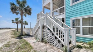 A beachfront property with a wooden deck, white railings, and a turquoise building. - Luxury 6 Bdrm/6 Ba Gulf Front w/Private Pool and Great Views (Gulf Shores)