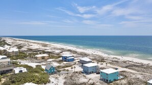 A coastal area with buildings near the beach, clear skies, and calm sea. - Luxury 6 Bdrm/6 Ba Gulf Front w/Private Pool and Great Views (Gulf Shores)