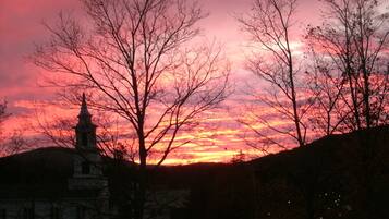 A sunset with a church silhouette and bare trees.