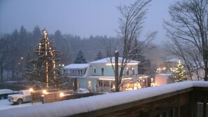 A residential area with snow-covered houses and a Christmas tree with lights. - TOWNHOUSE-Slp 8 Mt View/6 BEDS. Downtown Windham. Walk to restaurants and stores (Windham)