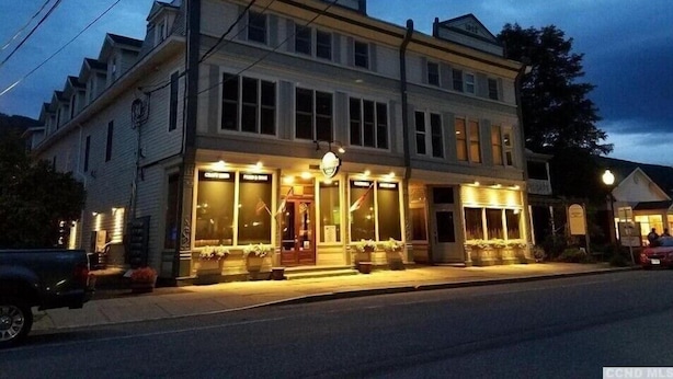 A two-story building with large windows and a storefront. - TOWNHOUSE-Slp 8 Mt View/6 BEDS. Downtown Windham. Walk to restaurants and stores (Windham)