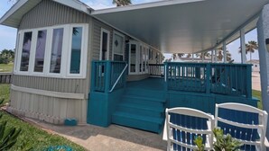 A two-story house with a covered porch, a staircase, and a small deck area. - Beach house on private resort (Port Isabel)