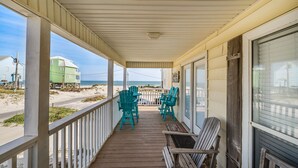 A covered porch with wooden flooring, white railings, and a view of the beach and ocean. - Cute beach house w/ramp for easy access. 3Bd/2Ba- Great Gulf Views/easy access. (Gulf Shores)