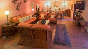 A living room with a sofa, chairs, a coffee table, and a dining area with a table and chairs. - Ocean View - In the Heart of Old Town -Casa Romance Escondido (Puerto Vallarta)