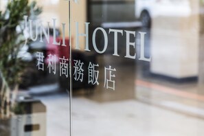 A hotel sign with the name "UNLI HOTEL" and some text in another language. - Junli Hotel (New Taipei City)
