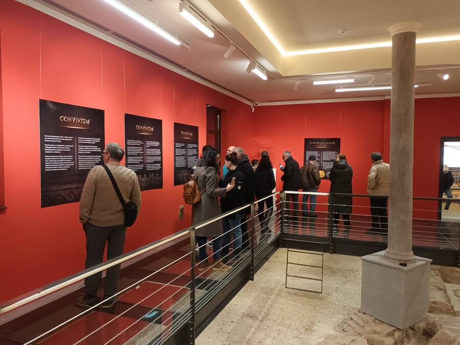 A red-walled hallway with informational posters and a metal railing.