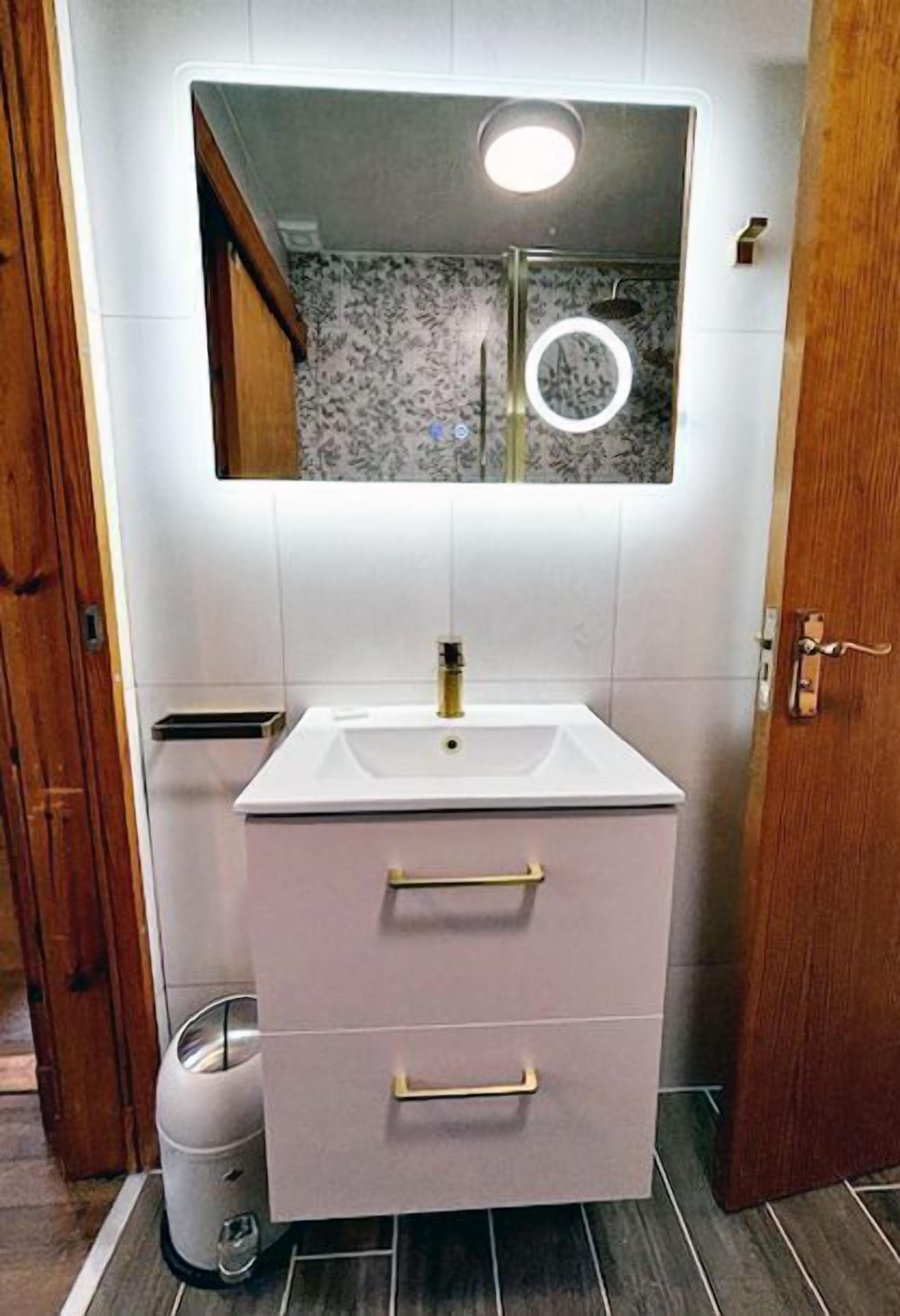 A bathroom with a white sink, a mirror, and a toilet.