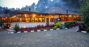 Traditional-style building with a thatched roof, surrounded by a well-maintained garden and a paved pathway.