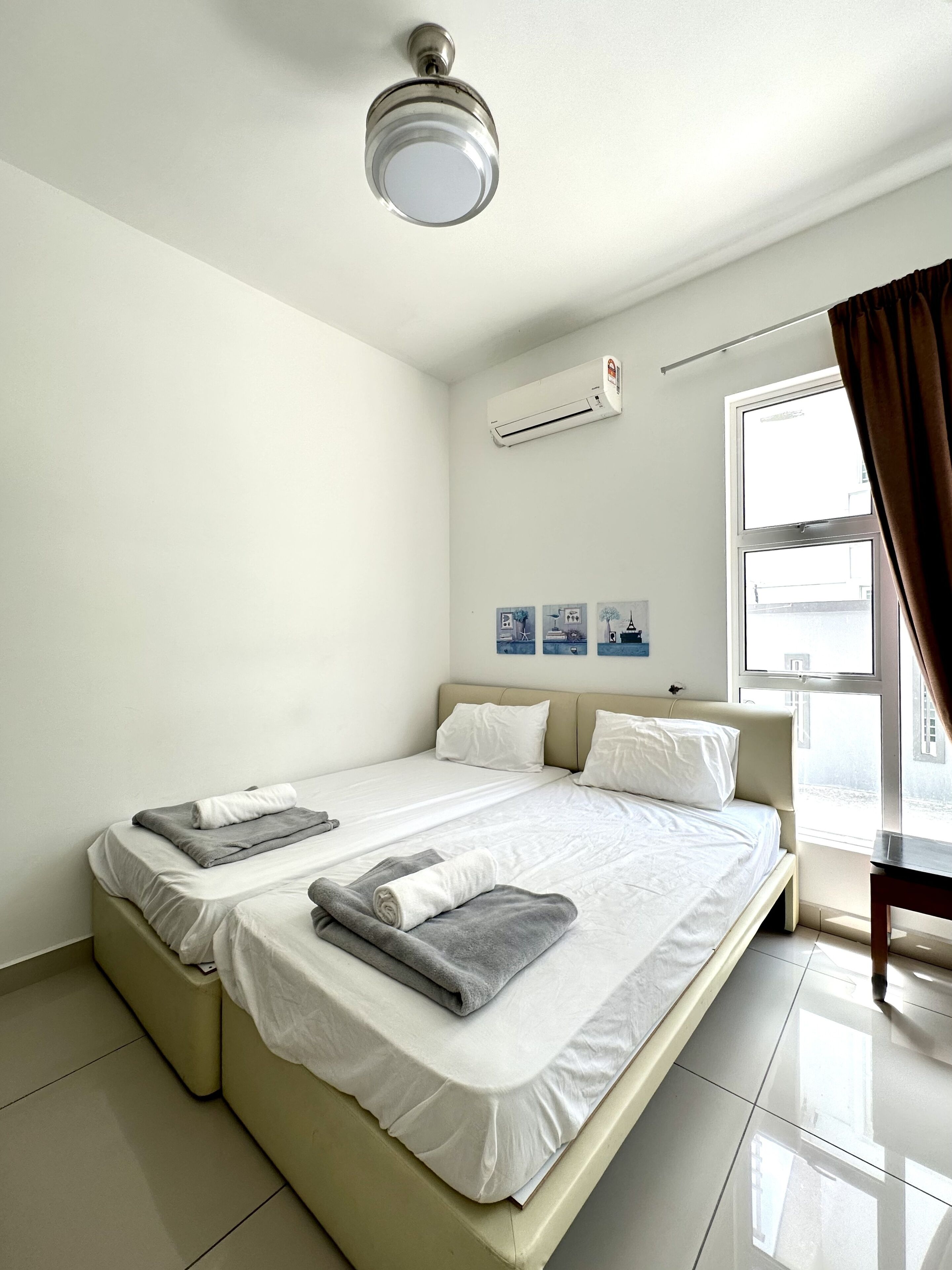 Una habitación de hotel con cama, ventana, aire acondicionado y cortina.
