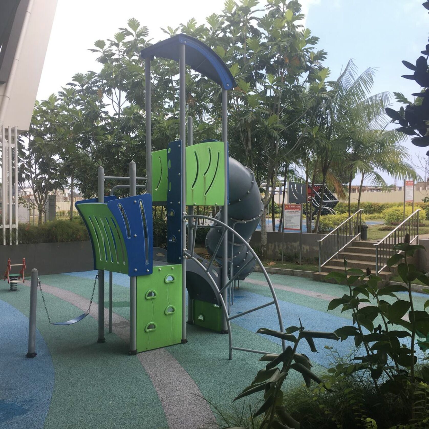 A playground with a slide, climbing structures, and a covered area.