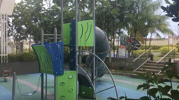 A playground with a slide, climbing structures, and a covered area.