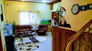 A living room with a brown leather sofa, a coffee table, a water dispenser, and a fish tank. - Venesis House (Sighisoara)