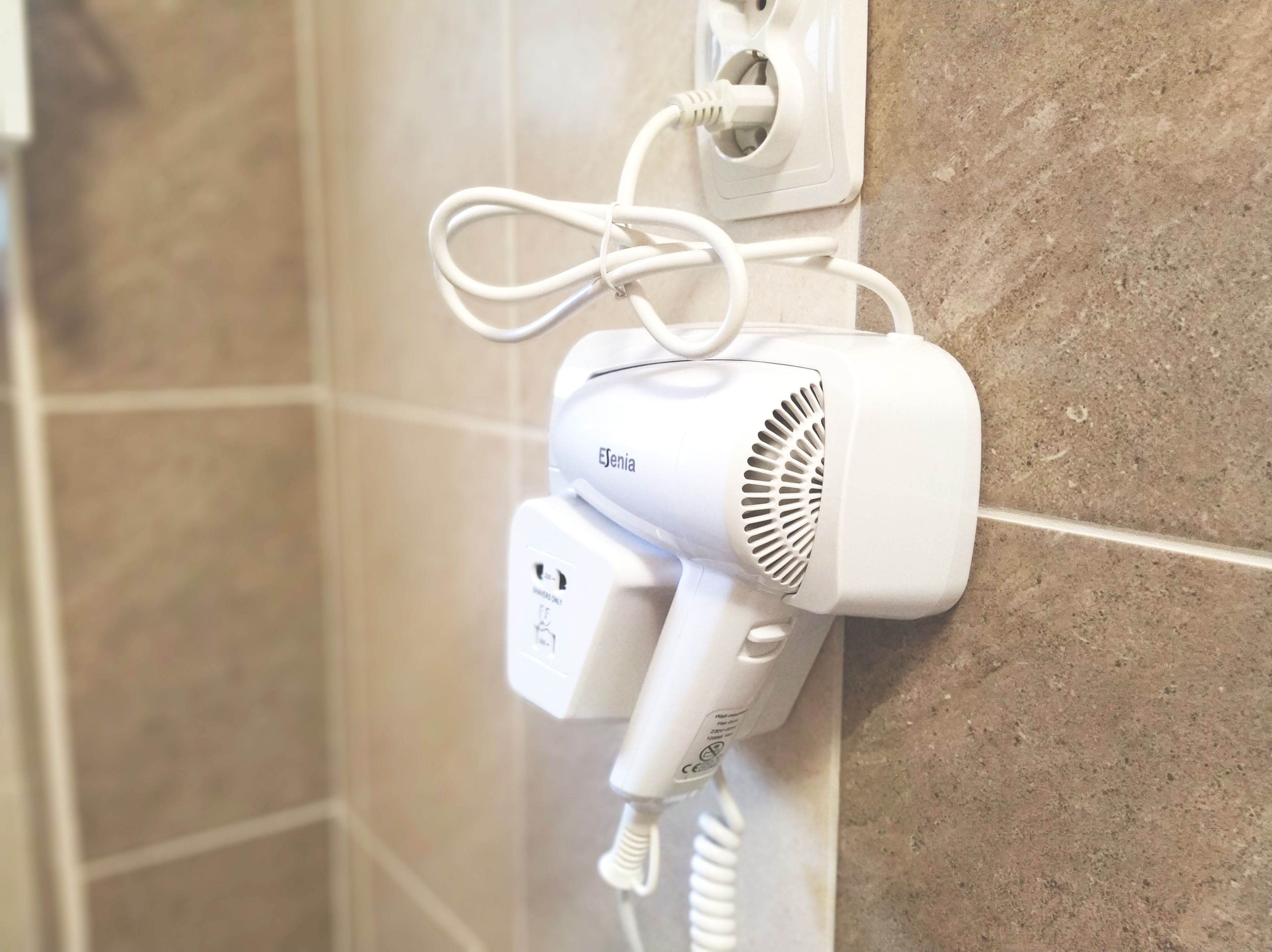 Un secador de pelo conectado a un enchufe de pared.