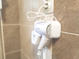 Un secador de pelo conectado a un enchufe de pared.