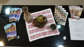 Una mesa con un menú, una botella, un adorno y postales.