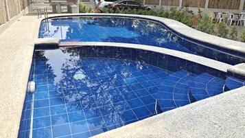 Une piscine dont le fond est carrelé et dont le bord est incurvé.