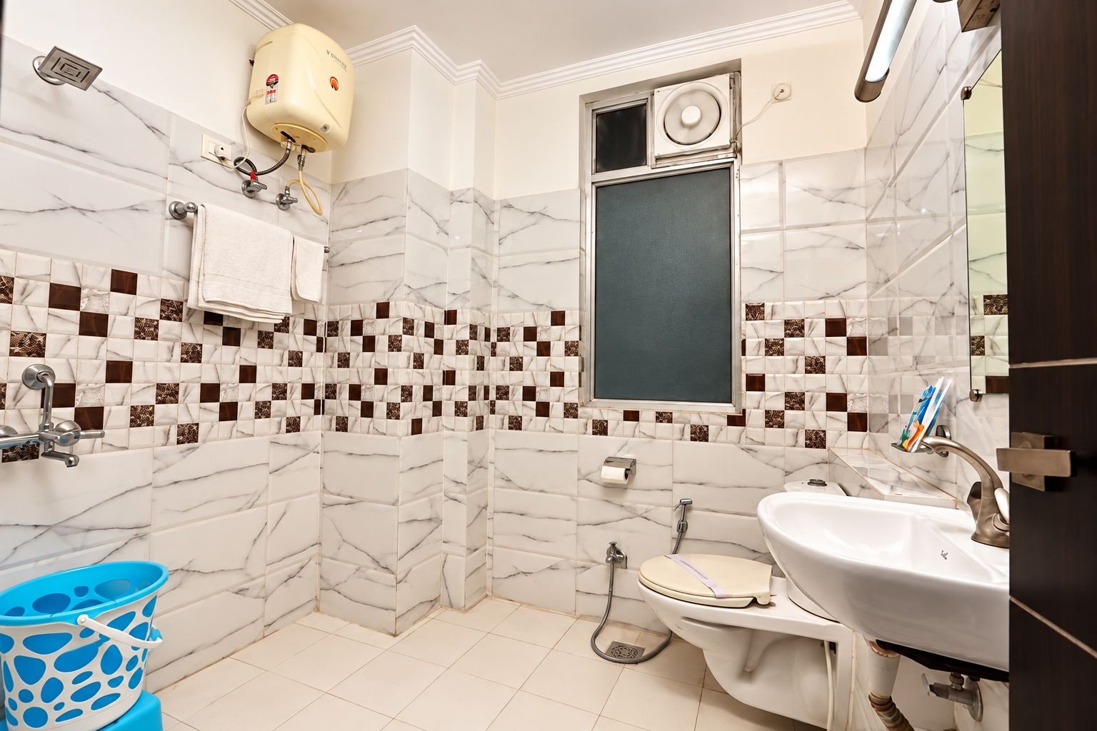 A bathroom with a white sink, a toilet, a shower, and a towel rack.