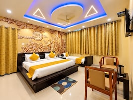 A hotel room with a large bed, a desk, and a chair.
