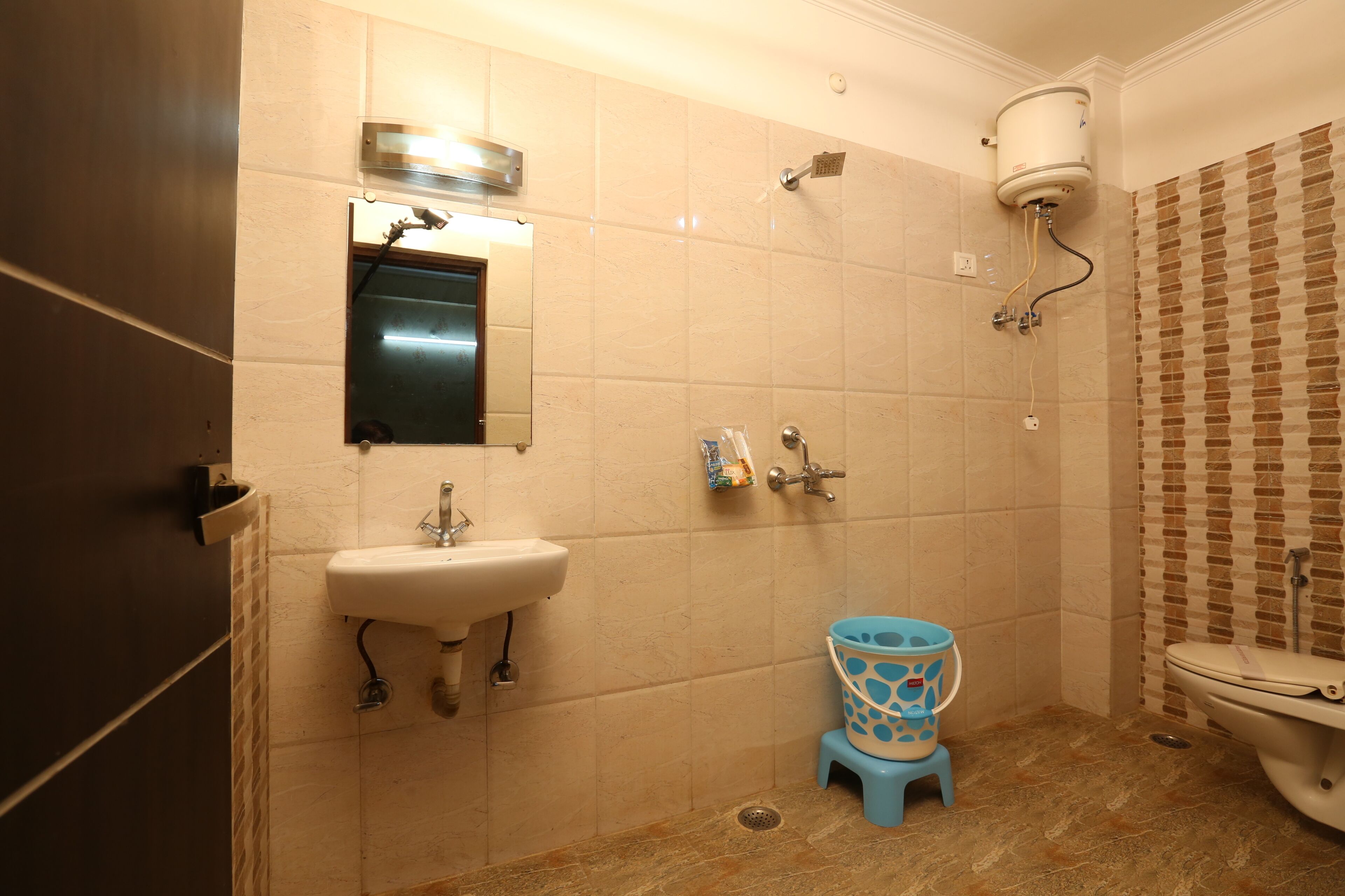 A bathroom with a sink, toilet, shower, and a mirror.