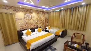 A hotel room with two beds, a desk, and a chair. - Hotel Nexus (Lucknow)