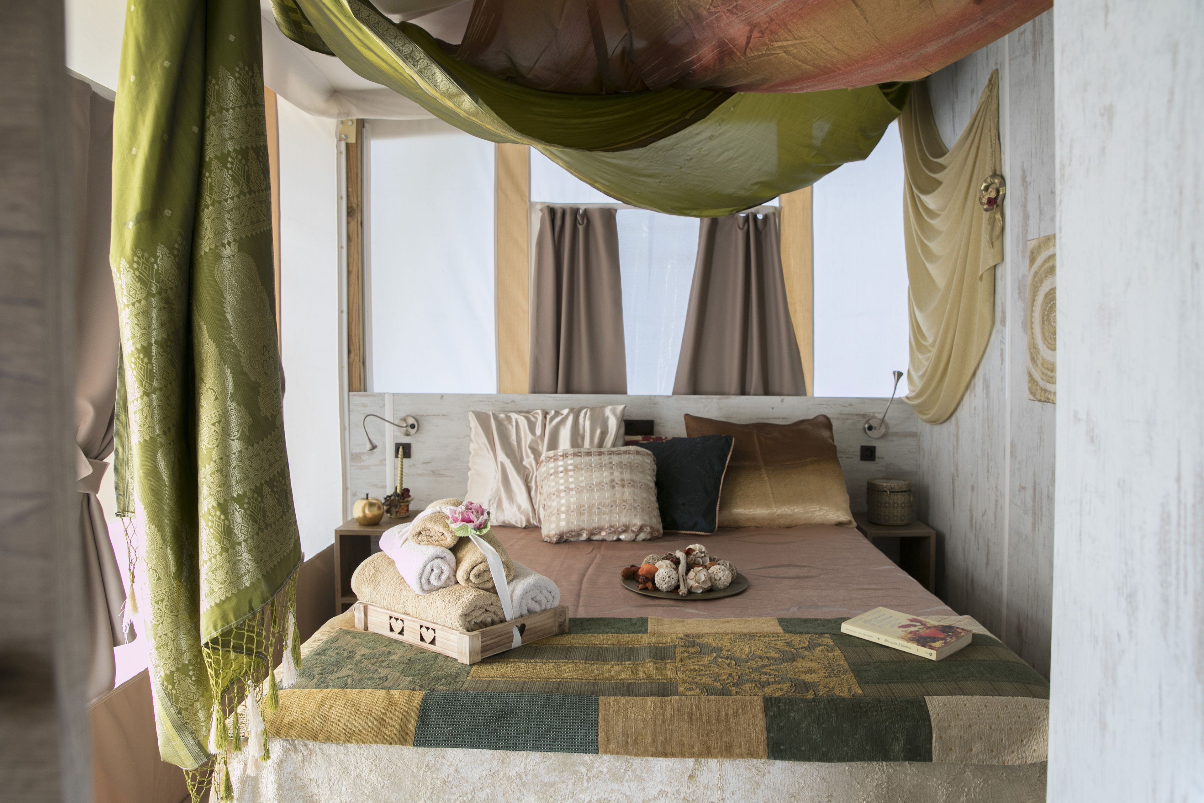 Une chambre à coucher avec un lit, des oreillers, une table de chevet et une fenêtre.